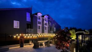 a building with lights on the side of it at night at Hôtel Blue Garden in Grandvillers