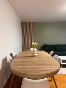 a dining room table with a vase of flowers on it at Résidence Les Oliviers, La Défense 20 mn, 4 to 6 people in Bezons +10 photos