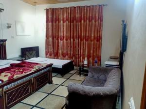 a bedroom with a bed and a chair and a couch at New moon soon hotel in Lahore +3 photos