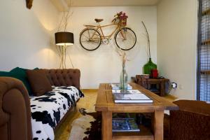 a living room with a couch and a bike on the wall at Bicis & Vacas in La Pola de Gordón