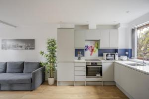 Una sala de estar con un sofá y una cocina. en Dukes Apartment by Stays Accommodation - Long Stays Welcome, en Chelmsford