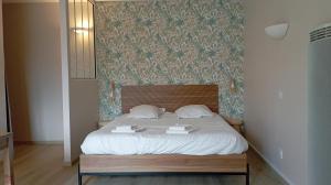 a bed with two books on it in a bedroom at Le cocon des Rosies le Eleanor Roosevelt in Colleville-sur-Mer