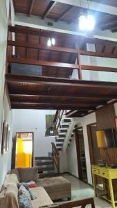 a living room with a couch and a staircase at Casa 05 - Grande Família in Angra dos Reis