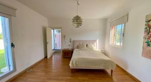 a bedroom with a bed in a room with windows at Skydiversnestdotcom in Bollullos de la Mitación +18 photos