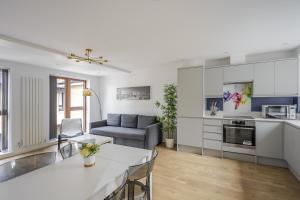 Una cocina y una sala de estar con un sofá y una mesa. en Dukes Apartment by Stays Accommodation - Long Stays Welcome, en Chelmsford