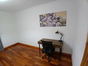 a desk with a lamp and a painting on the wall at Al-Solares in Santa Cruz