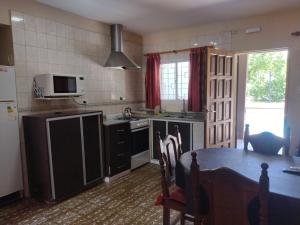 a kitchen with a table and a kitchen with a stove at Cabañas Los Pinos in Potrero de los Funes