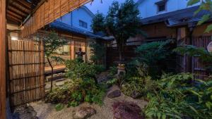 a garden in front of a building with a fence at Machiya Club Honkan in Omihachiman