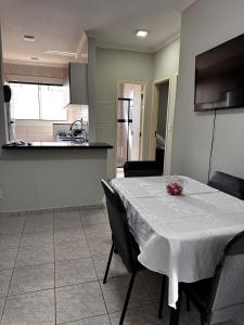 a dining room table with a white table cloth on it at Condominio Delville 2 quartos in Porto Velho
