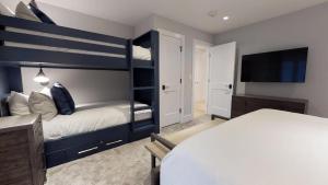 a bedroom with a bunk bed and a television at Christiania Condominiums- CoralTree Residence Collection in Vail