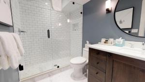 a bathroom with a toilet and a sink and a mirror at Christiania Condominiums- CoralTree Residence Collection in Vail +176 photos