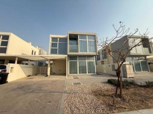 a large house with a tree in front of it at Spacious Fully Furnished 6BR Villa in Damac Hill2 in ‘Ūd al Bayḑāʼ