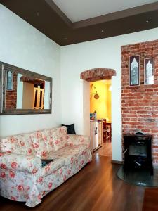 a living room with a couch and a brick fireplace at Petite Charlotte in Tarnów