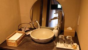 a bathroom counter with a sink and a mirror at Machiya Club Honkan in Omihachiman