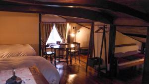 a bedroom with a bed and a table and a desk at Machiya Club Honkan in Omihachiman