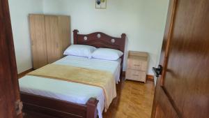 a bedroom with a bed with white sheets and a wooden headboard at Casa Campestre Villa Isabel tu Escape Perfecto in Cali