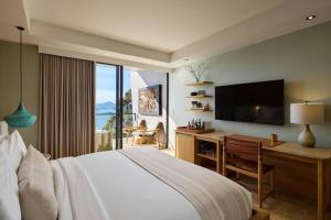 a bedroom with a bed and a desk with a television at The Brown, Guatape, Autograph Collection in Guatapé