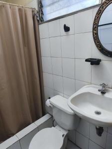 a bathroom with a toilet and a sink at Minidepartamento central en Ambato, para 1 a 8 personas en 3 Camas y un colchon in Ambato