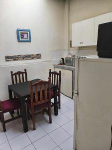 a kitchen with a table and chairs and a kitchen with a microwave at Minidepartamento central en Ambato, para 1 a 8 personas en 3 Camas y un colchon in Ambato