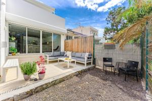 eine Terrasse eines Hauses mit einem Sofa und Stühlen in der Unterkunft Palmera Sky Terrace Suite in Las Galletas