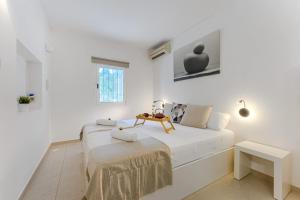 ein weißes Schlafzimmer mit einem Bett und einem Tisch in der Unterkunft Palmera Sky Terrace Suite in Las Galletas