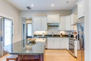 a kitchen with white cabinets and a granite counter top at 412A The Inlet House in Virginia Beach