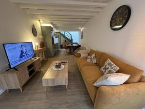 Escapade grenadoise في Larrivière: غرفة معيشة مع أريكة وتلفزيون