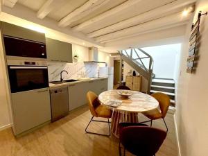 a kitchen with a table and chairs in a room at Escapade grenadoise in Larrivière