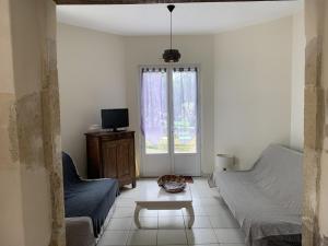 a living room with a couch and a table at A lines in Montsoué