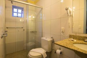a bathroom with a shower and a toilet and a sink at kitnet xixo 02 in Gramado