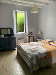 a bedroom with a bed and a window and a television at A lines in Montsoué
