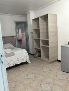 a bedroom with a bed and a book shelf at kitnet xixo 02 in Gramado