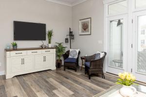ein Wohnzimmer mit Flachbildfernseher und Stühlen in der Unterkunft 525 The Back Bay House in Virginia Beach