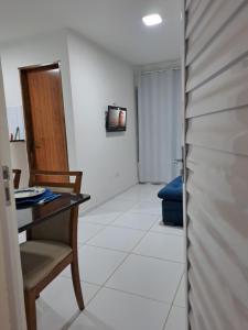 ein Zimmer mit einem Schreibtisch, einem Stuhl und einem Fernseher in der Unterkunft Apê econômico a 4 km de Muro Alto in Ipojuca