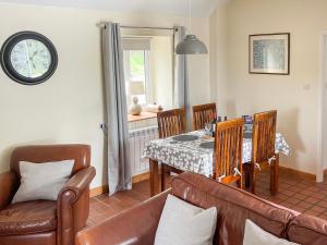 een woonkamer met een tafel en lederen stoelen bij The Smiddy in Glasserton