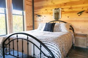 a bedroom with a bed in a log cabin at Bourbon Barrel Cottages #5 on Ky Bourbon Trail in Lawrenceburg