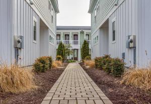 a brick walkway between two white buildings at 410B The King Neptune House in Virginia Beach