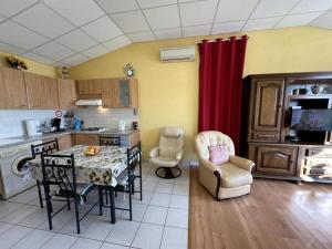 een keuken met een tafel en stoelen in een kamer bij Le gite de nogaro in Pontonx-sur-lʼAdour +2 foto's