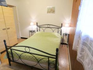 een slaapkamer met een groen bed met 2 lampen bij Le gite de nogaro in Pontonx-sur-lʼAdour