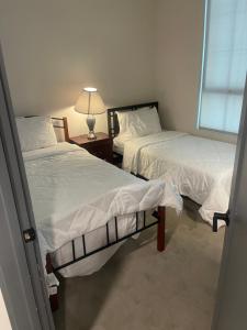 een kamer met 2 bedden en een tafel met een lamp bij express housing in Philadelphia