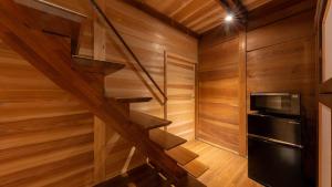 a staircase in a cabin with wooden walls and a microwave at まちや倶楽部別館 in Omihachiman