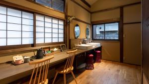 a bathroom with a sink and a counter with two chairs at まちや倶楽部別館 in Omihachiman