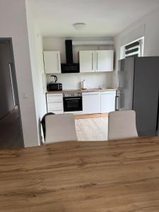 Ransbach-BaumbachにあるGanze Wohnung mit großem Parkplatz-Nähe A3の白いキャビネットとテーブルと椅子のあるキッチン