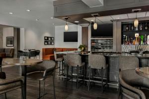 een bar in een restaurant met tafels en stoelen bij Chicago Marriott Midway in Bedford Park