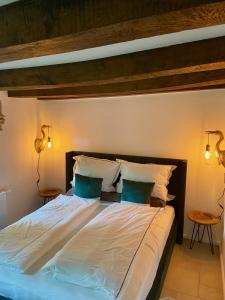 伦布鲁Cottage mit Kamin und Garten, seenah的一间卧室，有一张大床，配有两盏灯