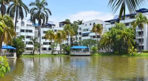 a large building with palm trees and a body of water at LAGOS DEL PEÑON 180 metros in Girardot