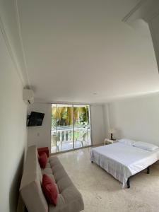 a white bedroom with a bed and a couch at LAGOS DEL PEÑON 180 metros in Girardot +38 photos