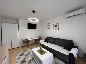 a living room with a black couch and a table at Central DELUXE Apartment in Prilep
