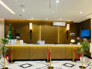 a lobby with a long yellow counter with redbons at رغدان فيو للشقق المخدومة in Al Baha