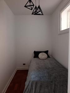 een slaapkamer met een bed met een kussen erop bij GuestHouse in Santiago
